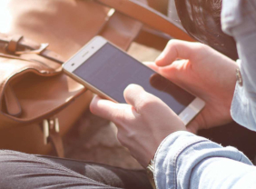 Junge Frau hält ein Smartphone in der Hand