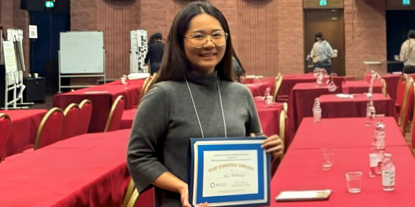 Rosa Behncke is holding her certicate for best poster. She is smiling.