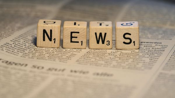 Auf dem Foto sieht man vier Scrabble-Würfel. Auf den Würfeln stehen die Buchstaben des Wortes NEWS.