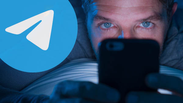 Mann liegt auf Bauch und schaut in Handy. Links daneben groß das Telegram-Logo: weißer Papierflieger auf blauem Grund