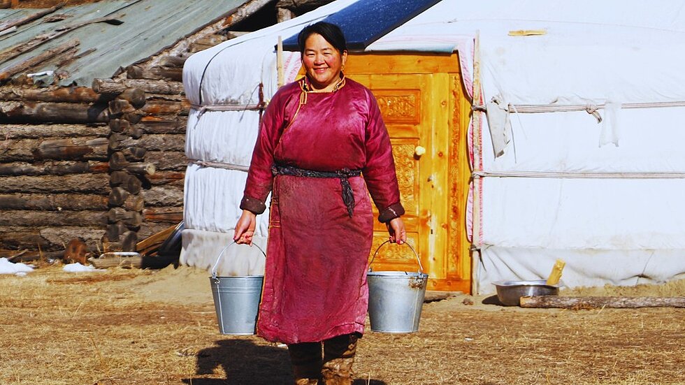 A woman carrying two buckets of milk 