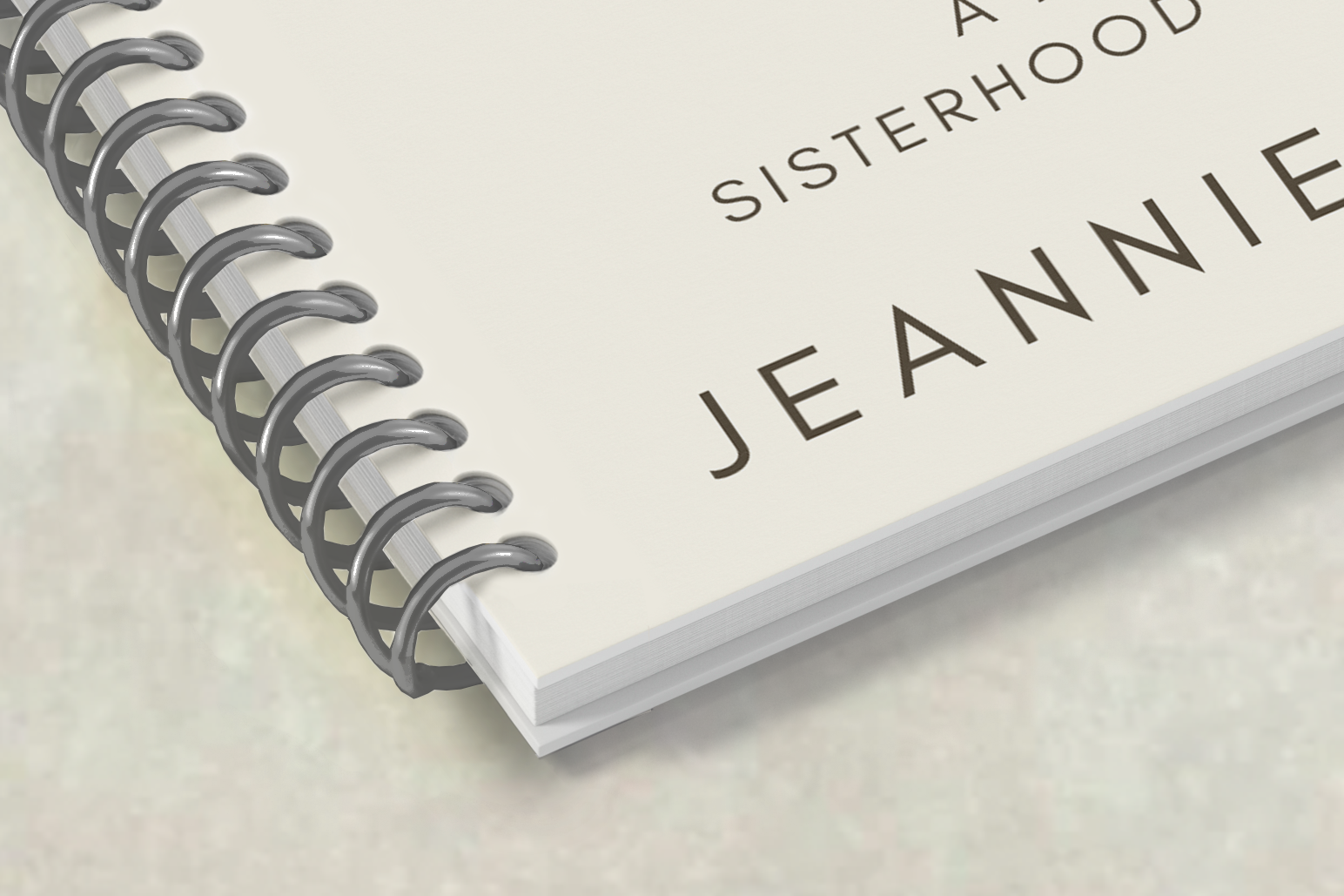 Close-up of a booklet corner showing spiral binding with a plastic coil threaded through punched holes.