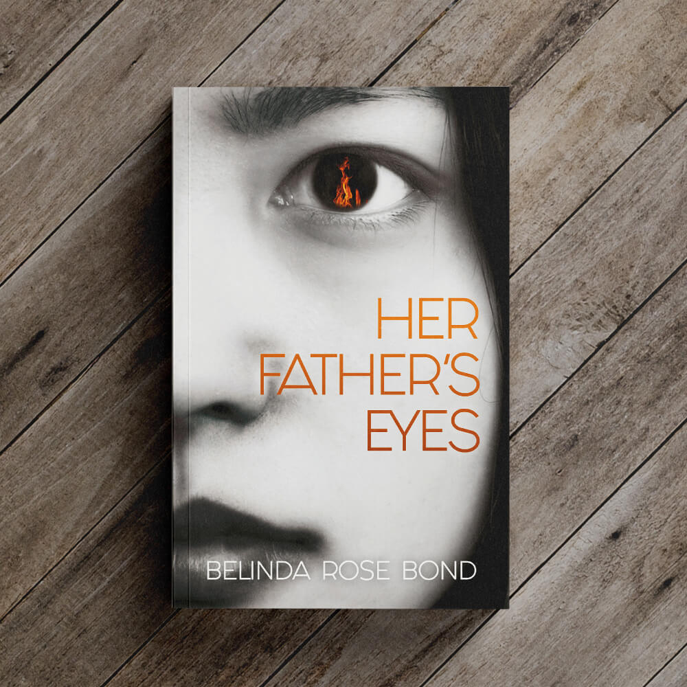 A closed paperback book called 'Her Father's Eyes'