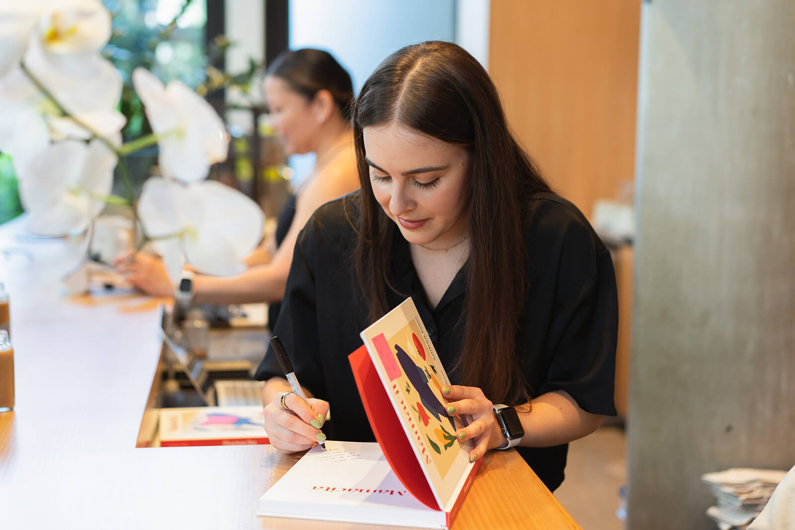 An author signs her self-published hardcover cookbook at an event