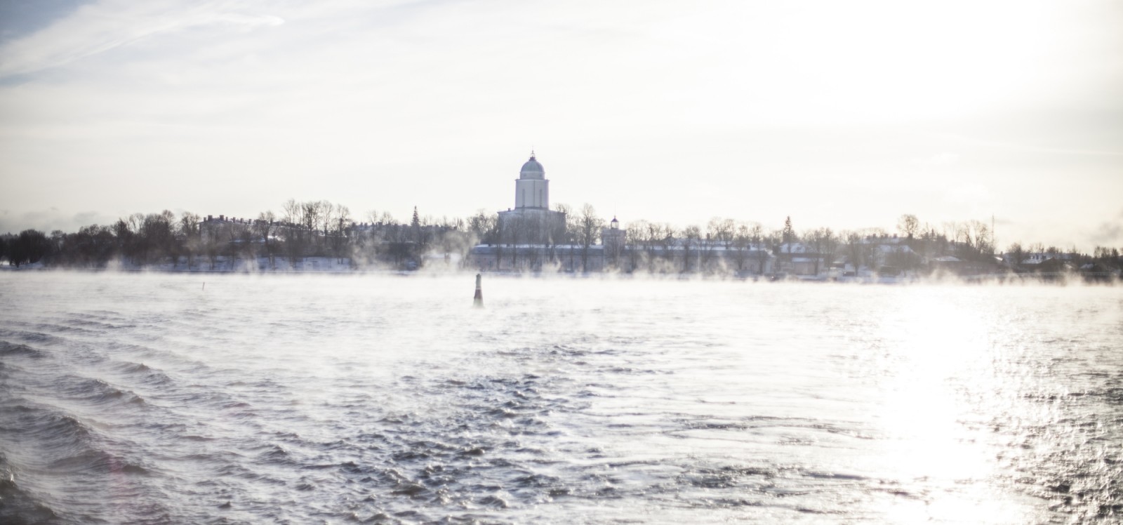 Suomenlinnan kirkko lautalta kuvattuna. Merisumu tuo kuvaan hyisen kylmän tunnelman.