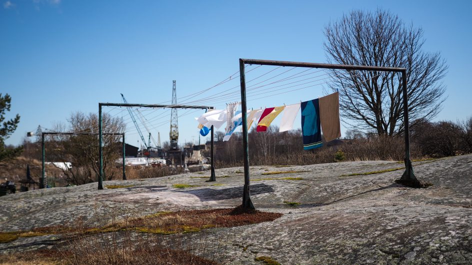 Kallion päällä oleva pyykkiteline, missä liehuu erilaisia pyykkejä kuivumassa
