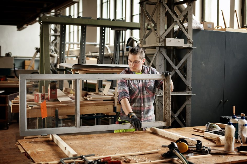 Puuseppä työstää vanhaa ikkunaa puusepän verstaalla