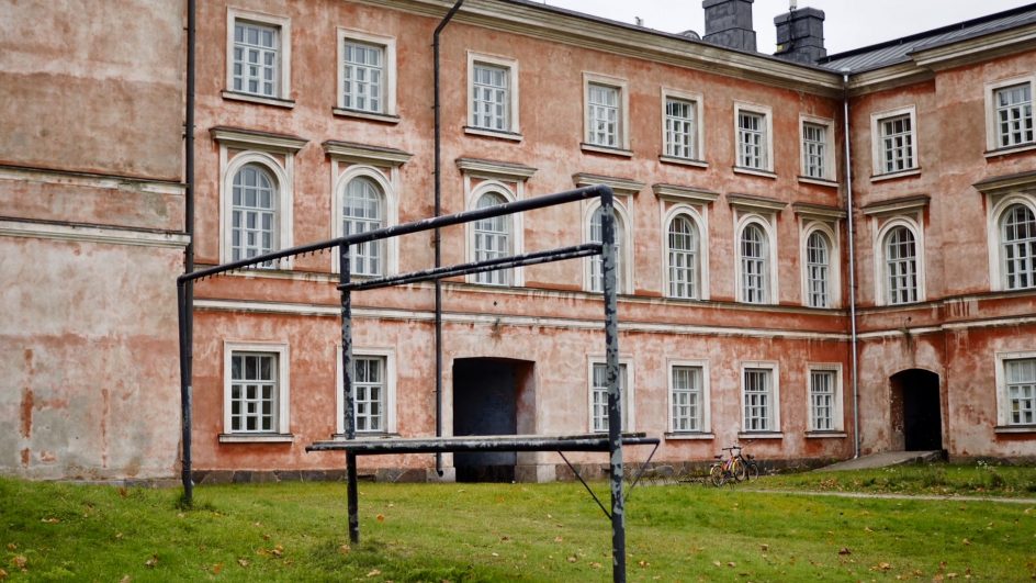 Vaasan kasarmin rakennus, jonka edessä mattojen tamppausteline ja vihreä nurmikko