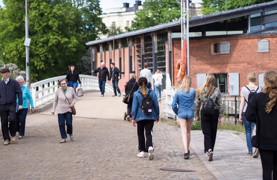 Kuvassa matkailijoita kävelemässä Susisaaren sillalla kesällä