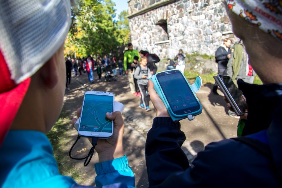 Lapset pelaavat Pokémon Go -puhelinsovellusta Suomenlinnassa.