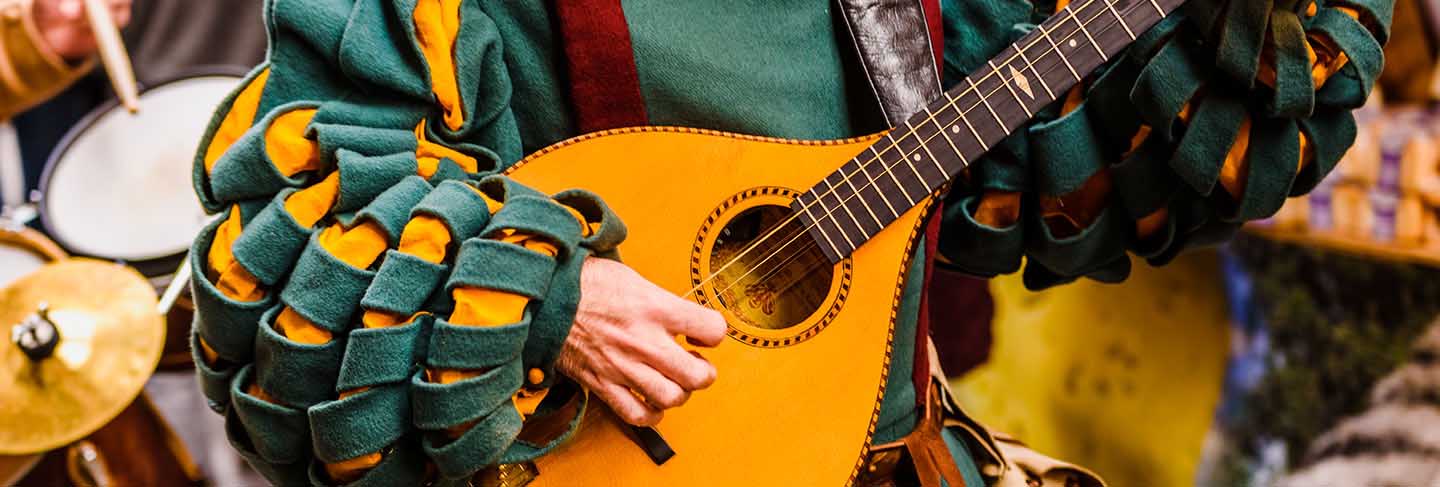 Medieval troubadour playing an antique guitar.