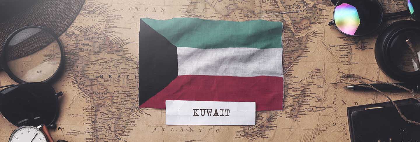 Kuwait flag between traveler's accessories on old vintage map