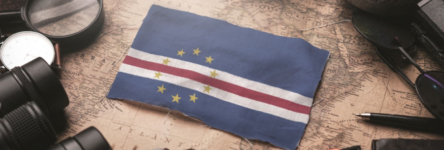 Cape verde flag between traveler's accessories on old vintage map. tourist destination concept.