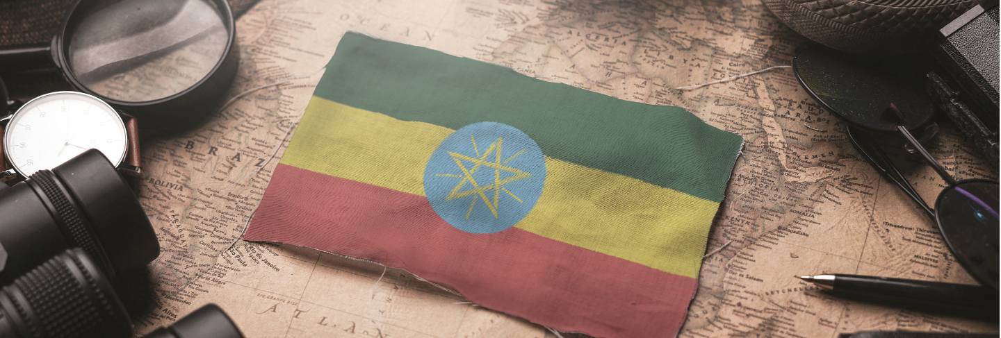 Ethiopia flag between traveler's accessories on old vintage map. tourist destination concept.