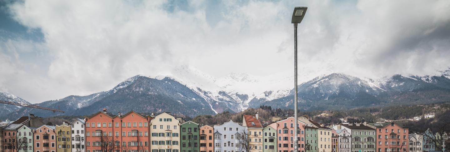 View of the historic city center of innsbruck with colorful houses along inn river and famous austrian mountain summits in the background with a bike, tyrol, austria