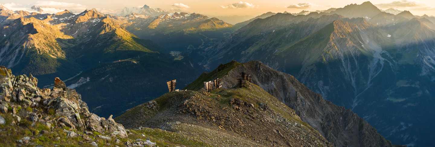 Warm light at sunrise on mountain peaks, ridges and valleys