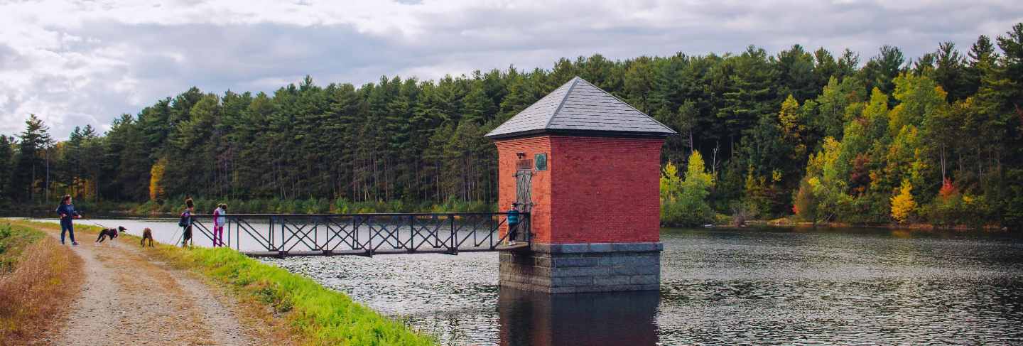 Small red hut built on a river and connected to a bridge with amazing natural scenery