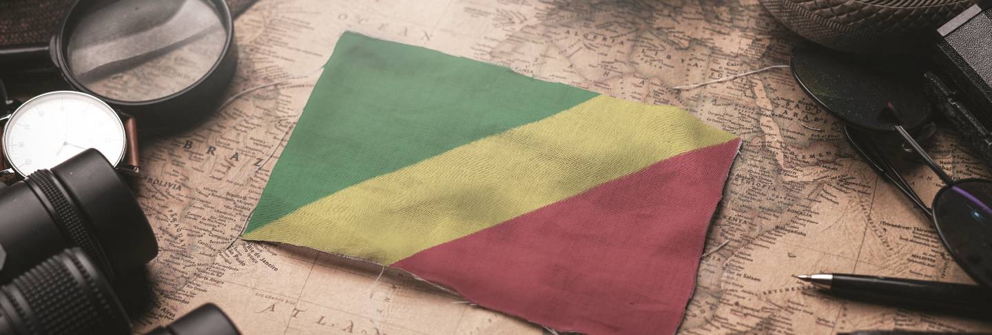 Republic of the congo flag between traveler's accessories on old vintage map. tourist destination concept.