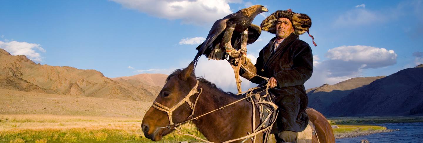 Mongolian man on a horse with an eagle