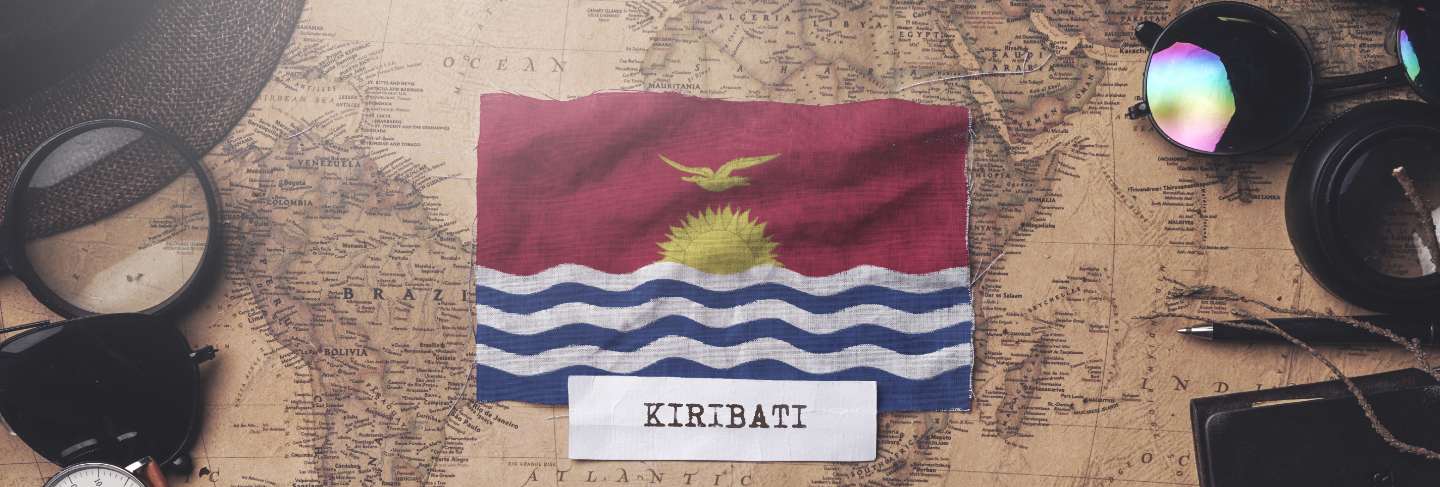 Kiribati flag between traveler's accessories on old vintage map