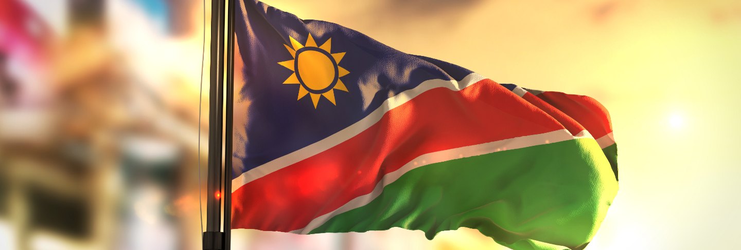 namibia-flag-against-city-blurred-background-sunrise-backlight