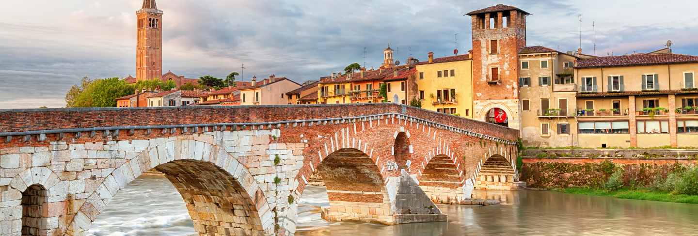 Famous verona landmark. ponte di pietra over adige river during sunrise.