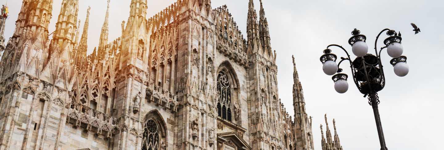 Beautiful panoramic view of duomo square in milan with big street lamp. italy.