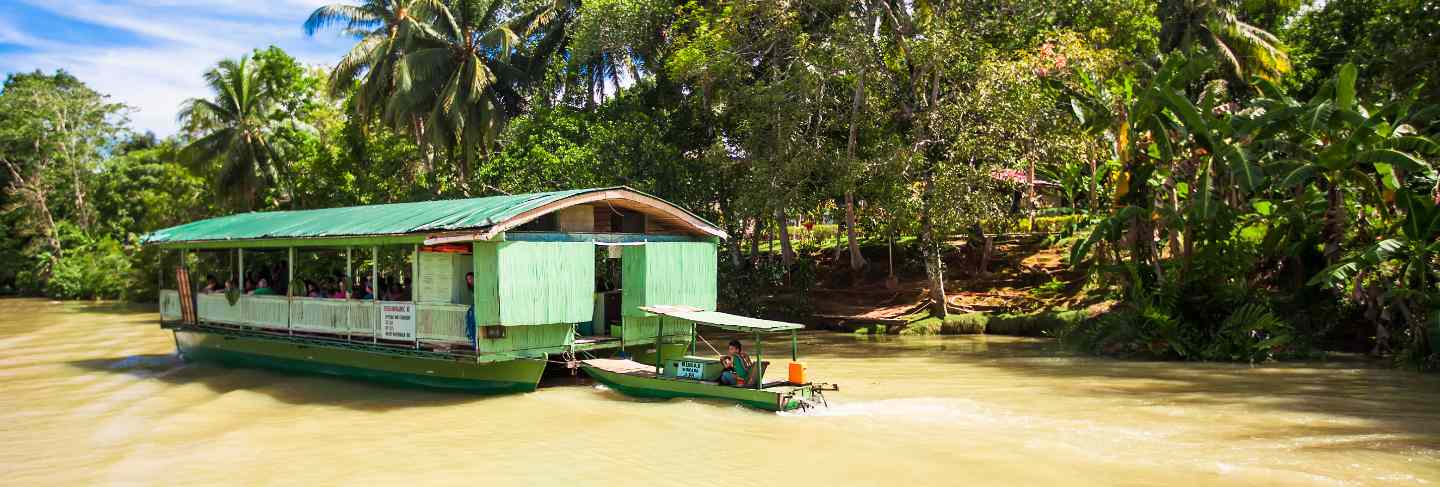 Exotic cruise boat with tourists on a jungle river loboc, bohol