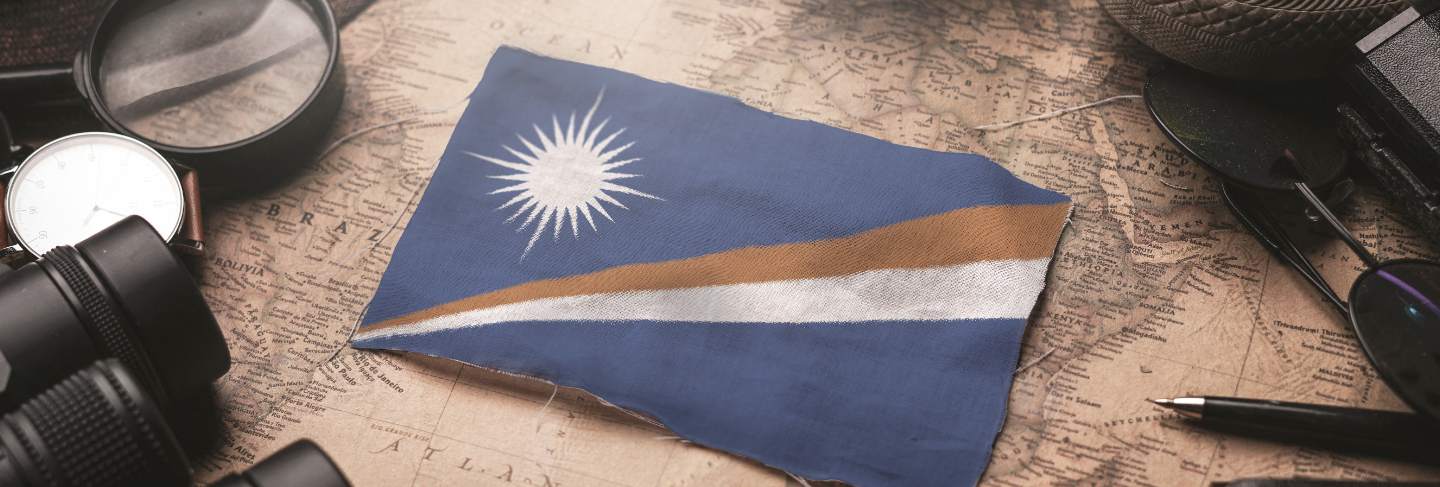 Marshall islands flag between traveler's accessories on old vintage map. tourist destination concept
