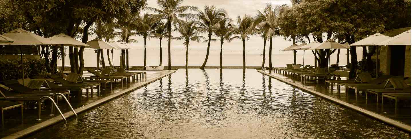 Silhouette palm tree on the beach with swimming pool