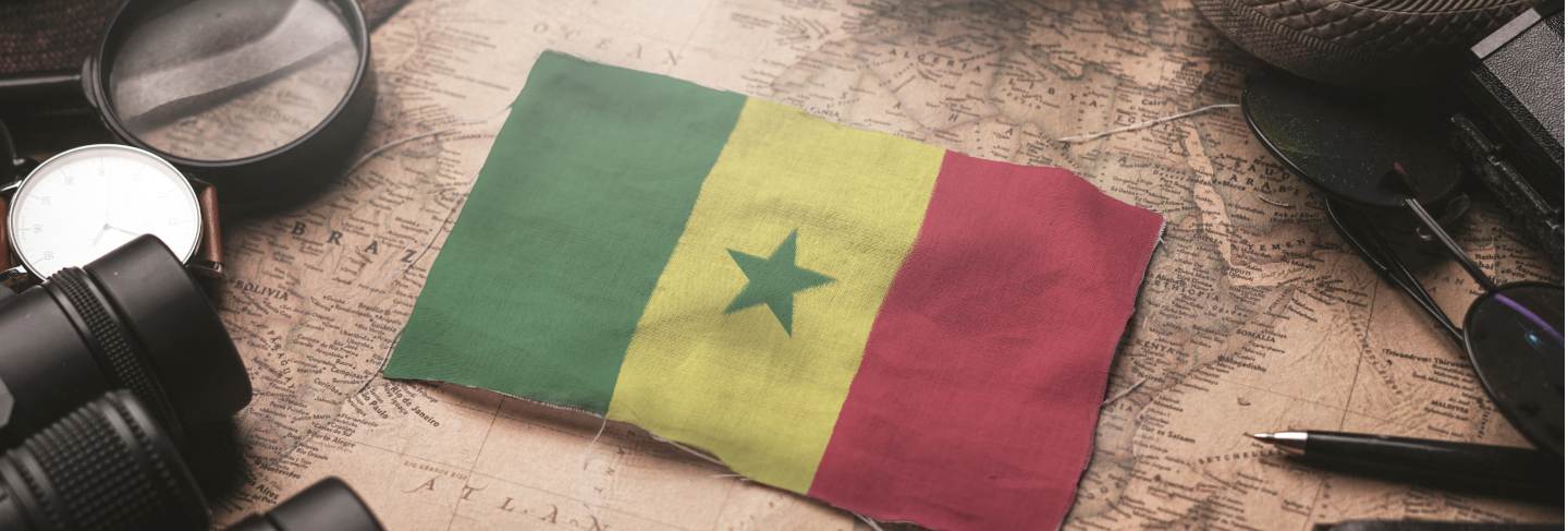 Senegal flag between traveler's accessories on old vintage map. tourist destination concept. Premium Photo