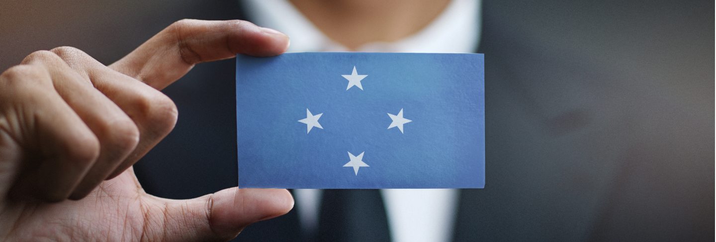 Businessman holding card of federated states of micronesia flag Premium Photo