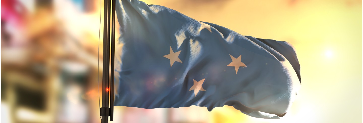 Federated states of micronesia flag against city blurred background at sunrise backlight Premium Photo