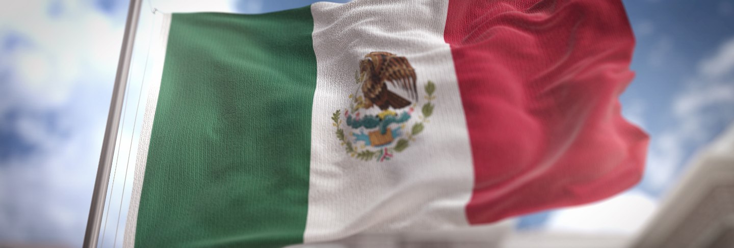 Mexico flag 3d rendering on blue sky building background