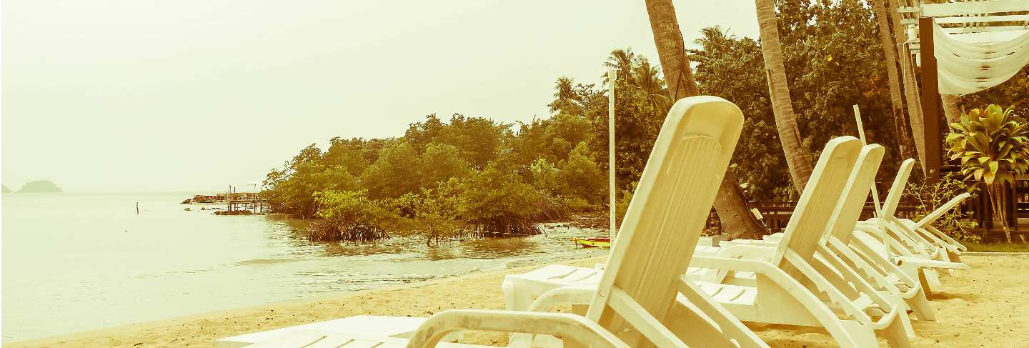 Beautiful silhouette luxury umbrella and chair around swimming pool in hotel pool resort with coconut palm tree at sunrise times - vintage filter and boost up color processing