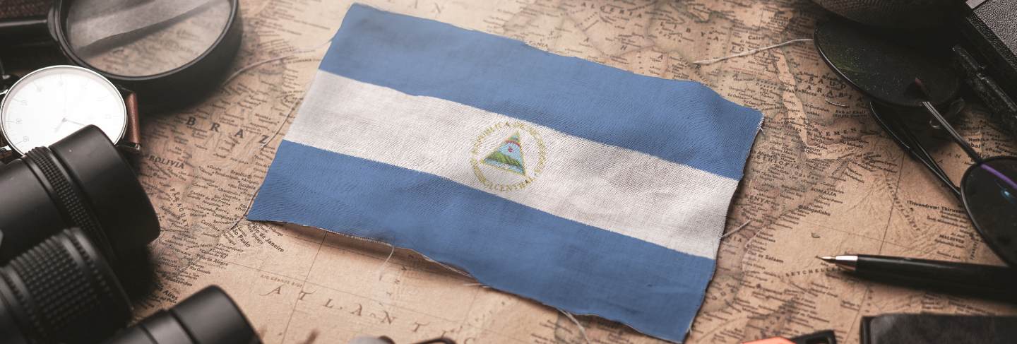 Nicaragua flag between traveler's accessories on old vintage map. tourist destination concept