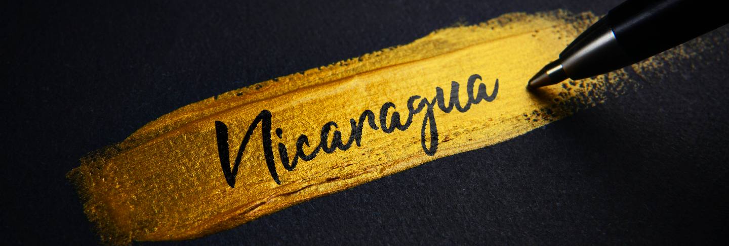 Nicaragua handwriting text on golden paint brush stroke