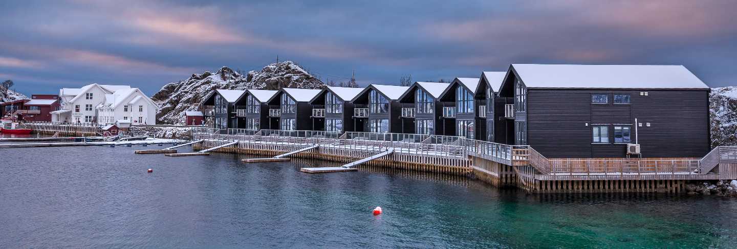 Blue hour after sunset time in winter season, village is covered with snow. the famous tourist attraction hamn village, senja islands