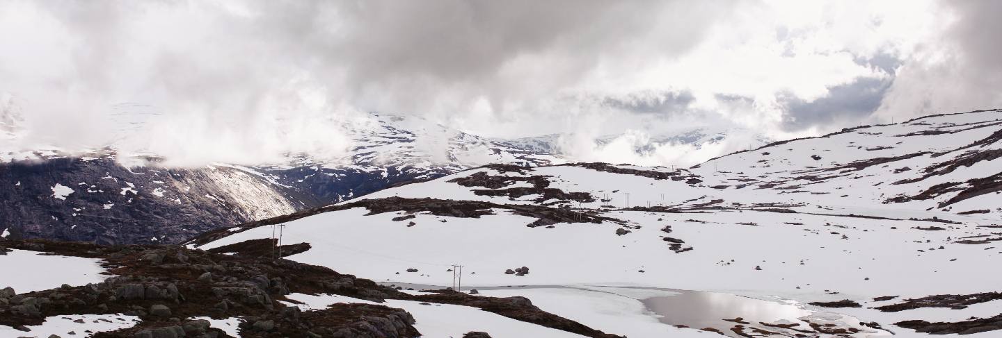 Snow lies before blue rock summints in norway