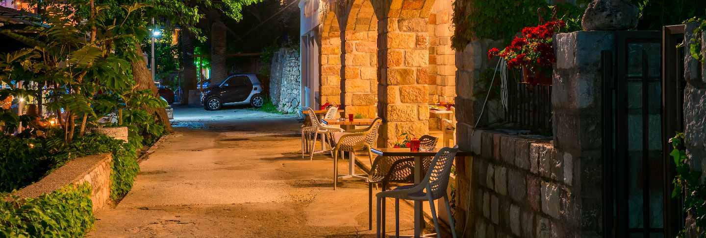 Restaurant staff prepared their tables near the sea for dinner during sunset