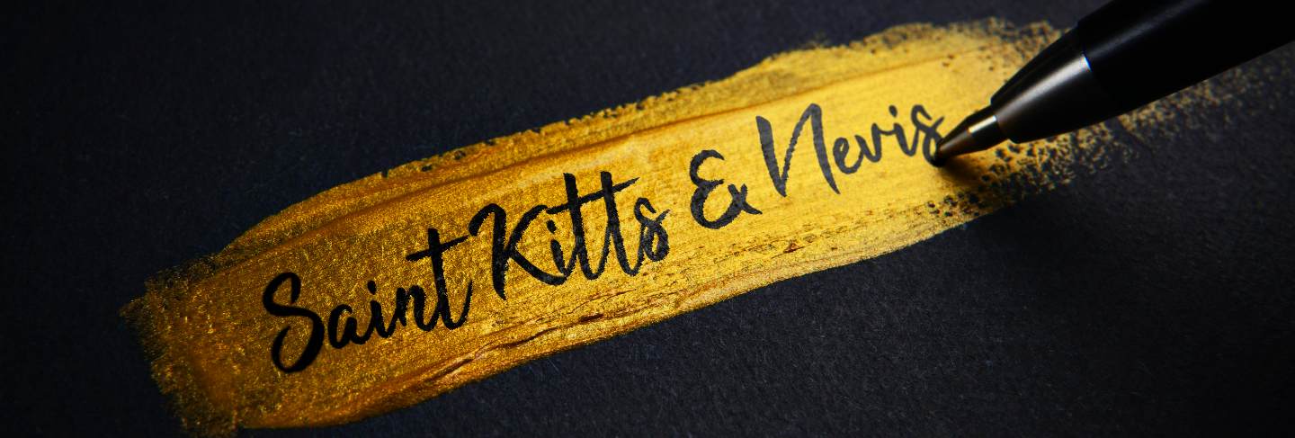 Saint kitts and nevis handwriting text on golden paint brush stroke