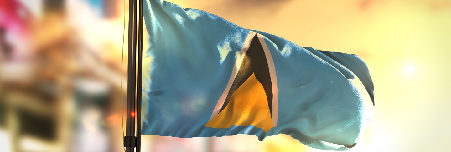 Saint lucia flag against city blurred background at sunrise backlight