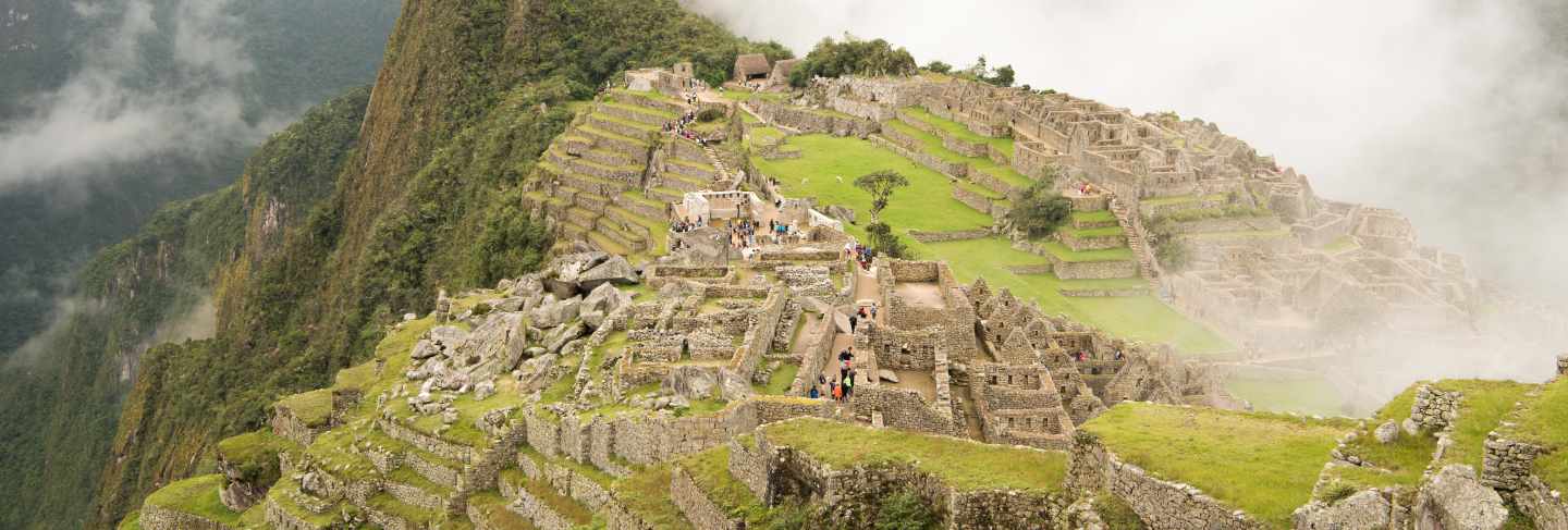 High angle of the beautiful machu picchu citadel surrounded by foggy mountains in urubamba, peru