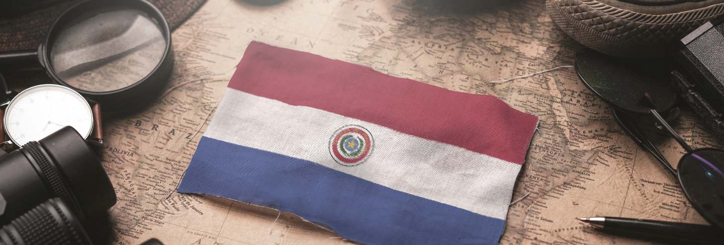 Paraguay flag between traveler's accessories on old vintage map. tourist destination concept.