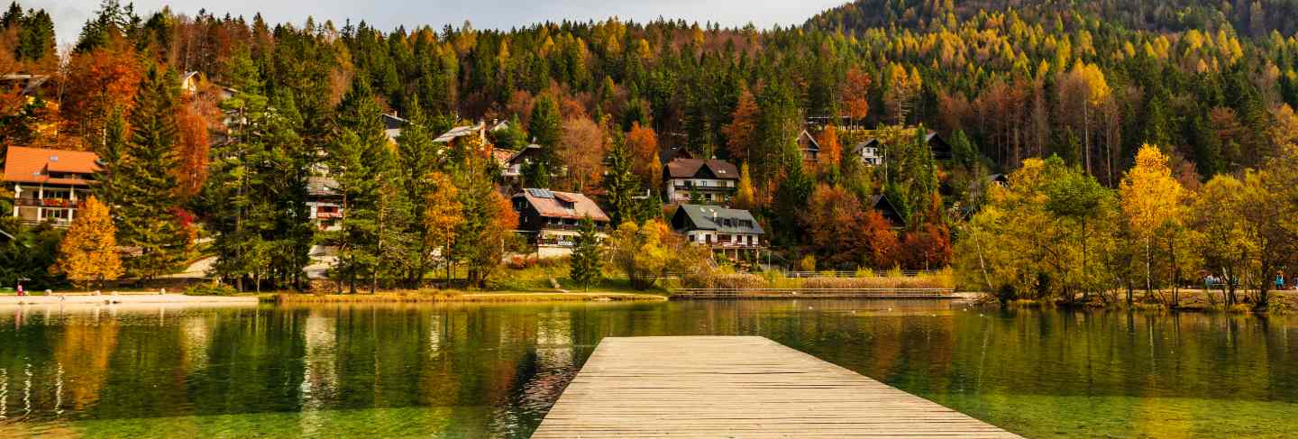 Wooden pier on amazing lake jasna in autumn season, slovenian alps