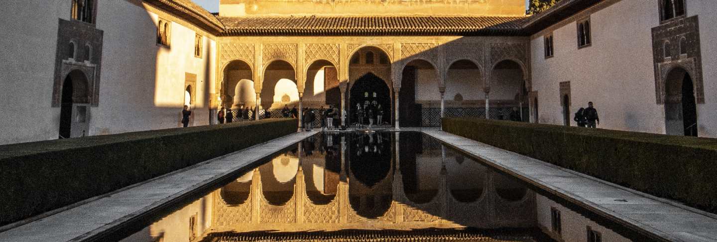 Beautiful vertical shot of a great palace in spain with the reflection in the pool