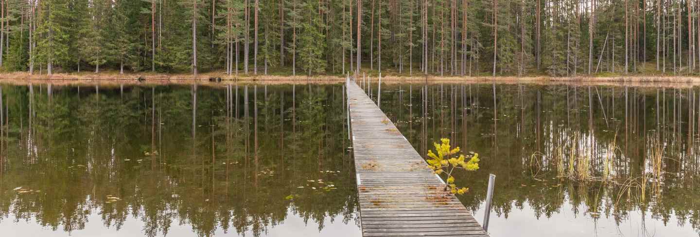 Wooden pier leading to the opposite shore, autumn landscape. sweden.