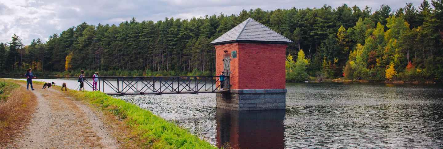 Small red hut built on a river and connected to a bridge with amazing natural scenery
