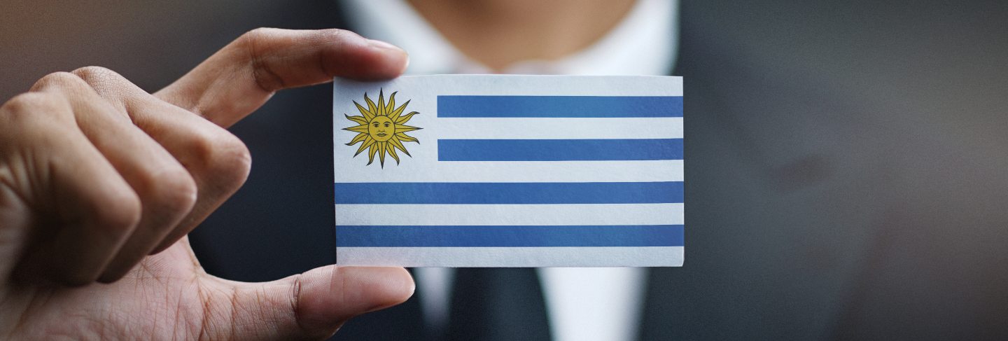 Businessman holding card of uruguay flag