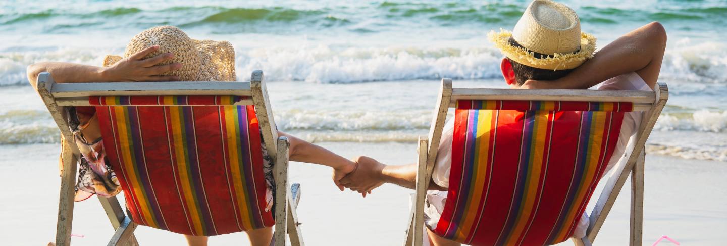 Relax couple lay down on beach chiar with sea wave - man and woman have vacation at sea nature concept